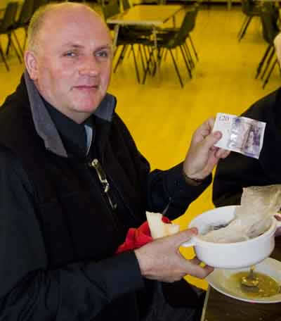Fr. Gubbins puts his donation towards Cafod in the collection bowl