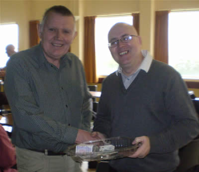SVP member Alex Mackie presents the proceeds of their coffee morning