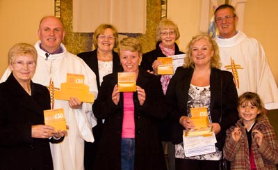 A group of parishioners show their '&pound;50 a day' priest training fund boxes.